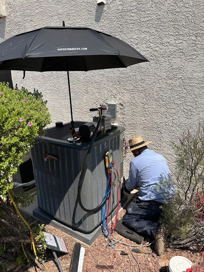 HVAC technician performing outdoor AC maintenance in Macomb